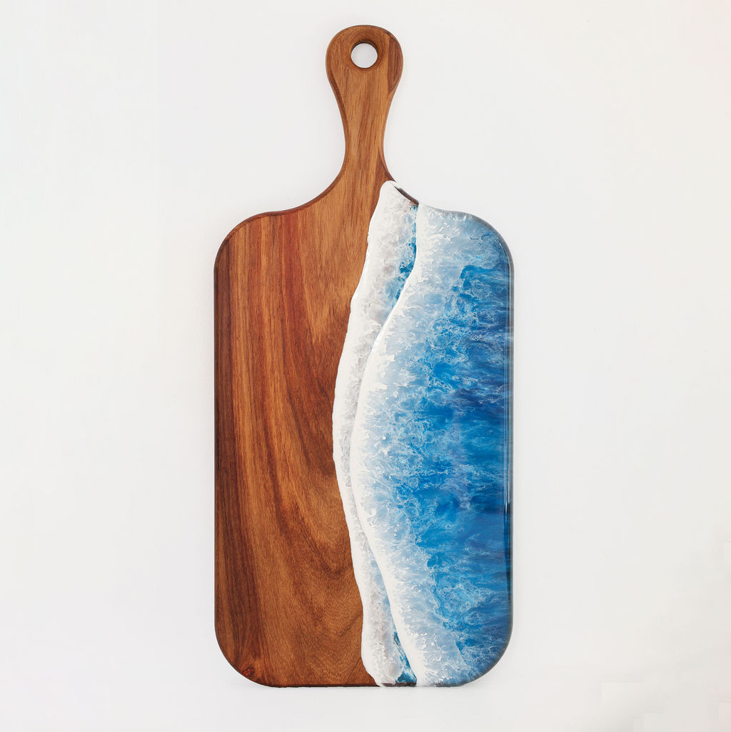 Front view of handcrafted large paddle serving board made from kiaat wood with blue ocean resin wave design