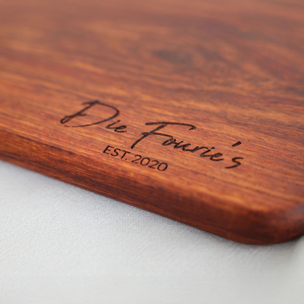 Close-up of personalised engraving on a handcrafted kiaat wood serving board