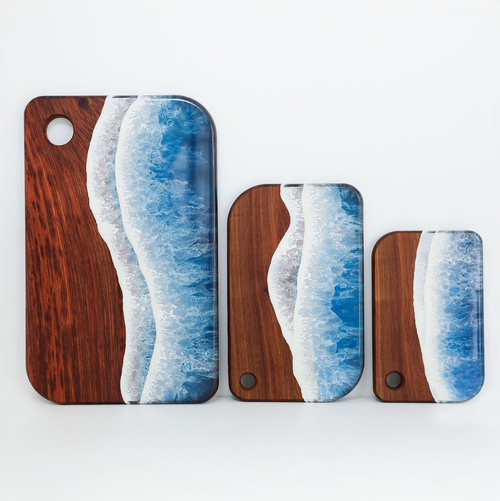 Handcrafted large, medium and small rectangle serving boards with blue ocean resin wave design shown together to compare sizes