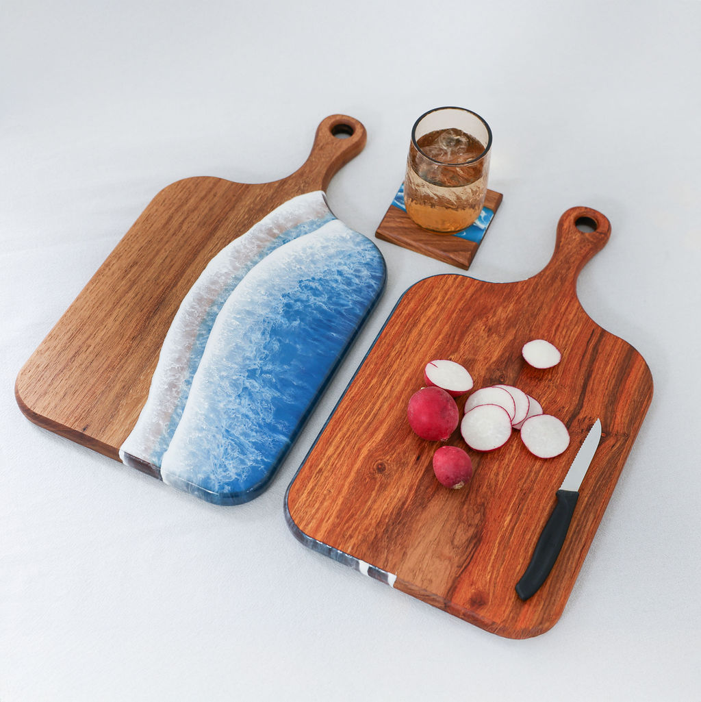 Handcrafted medium paddle serving board showing ocean resin wave display side and kiaat wood chopping side with radishes