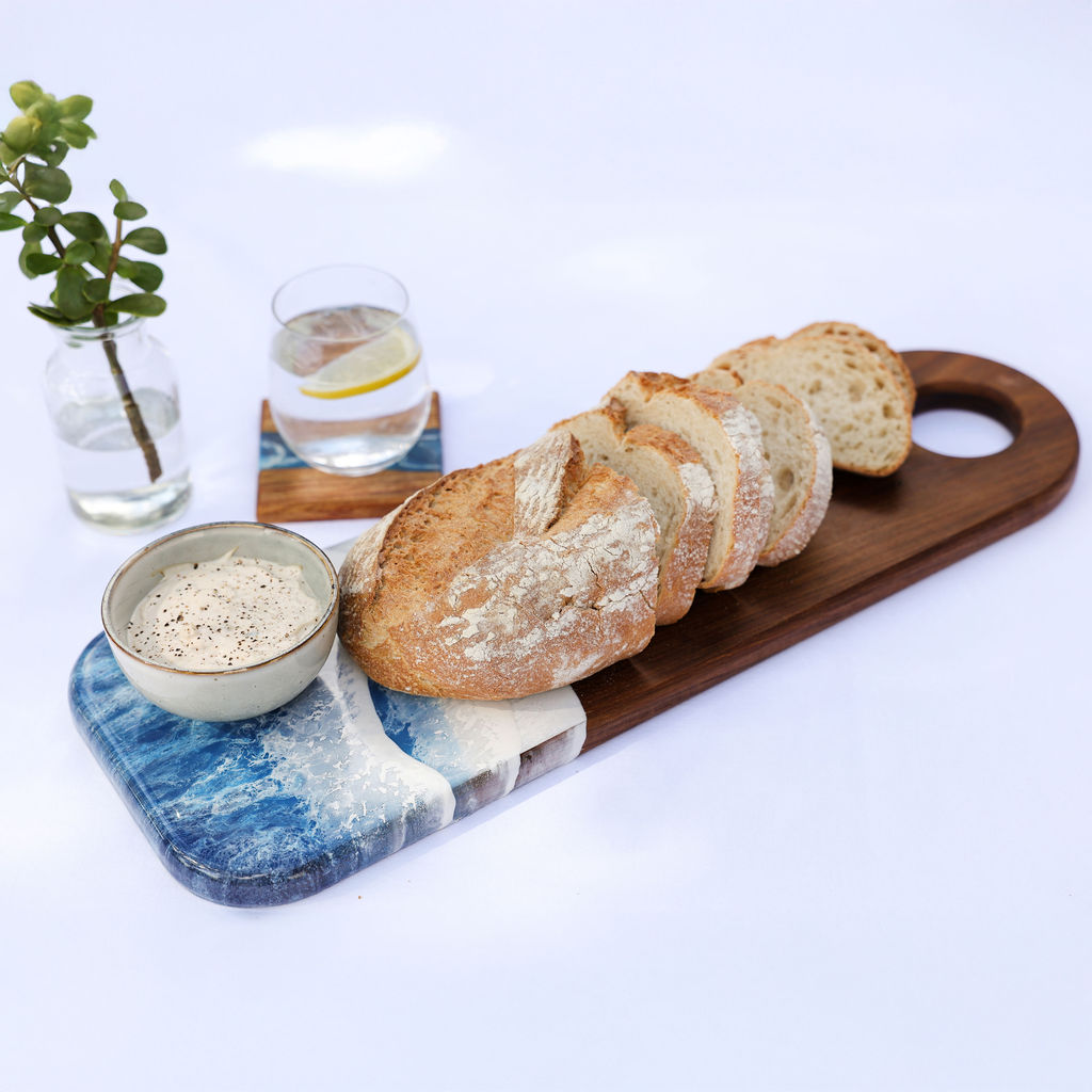 Handcrafted long serving board with ocean resin wave design, Tidal coaster set, bread, and dips