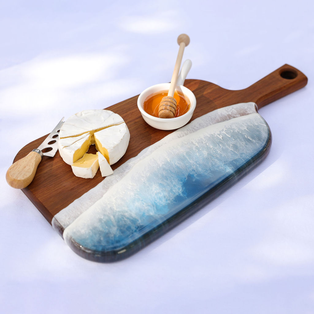 Handcrafted organic medium paddle serving board with ocean resin wave design styled for entertaining