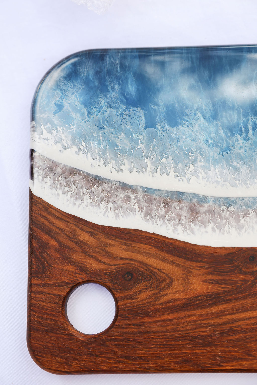 Close-up view of kiaat wood grain and ocean resin wave design