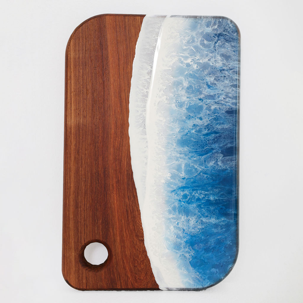 Front view of handcrafted small rectangle kiaat wood serving board with blue ocean resin wave design