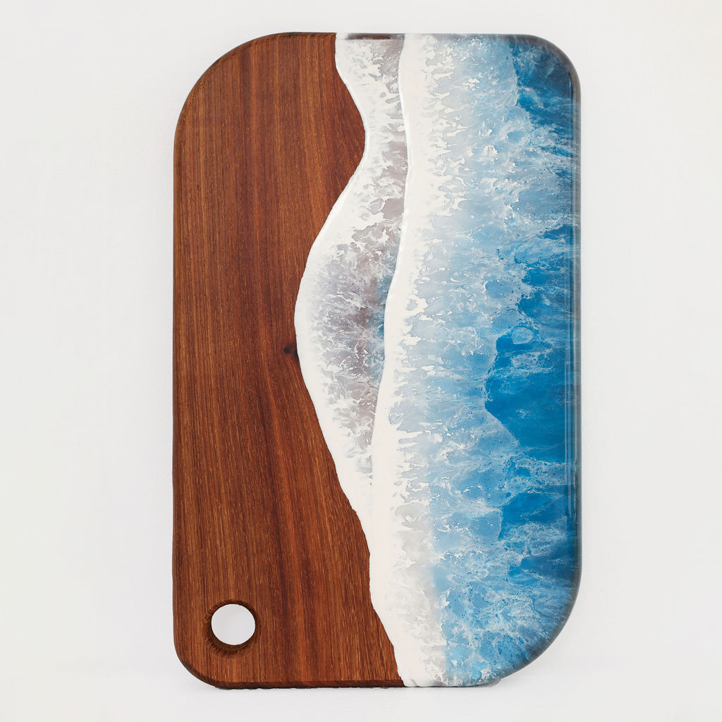 Front view of handcrafted medium rectangle kiaat wood serving board with blue ocean resin wave design