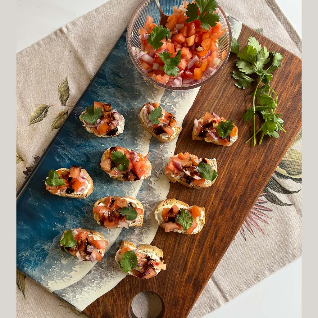 Handcrafted large rectangle serving board with ocean resin wave design styled with a variety of foods for entertaining